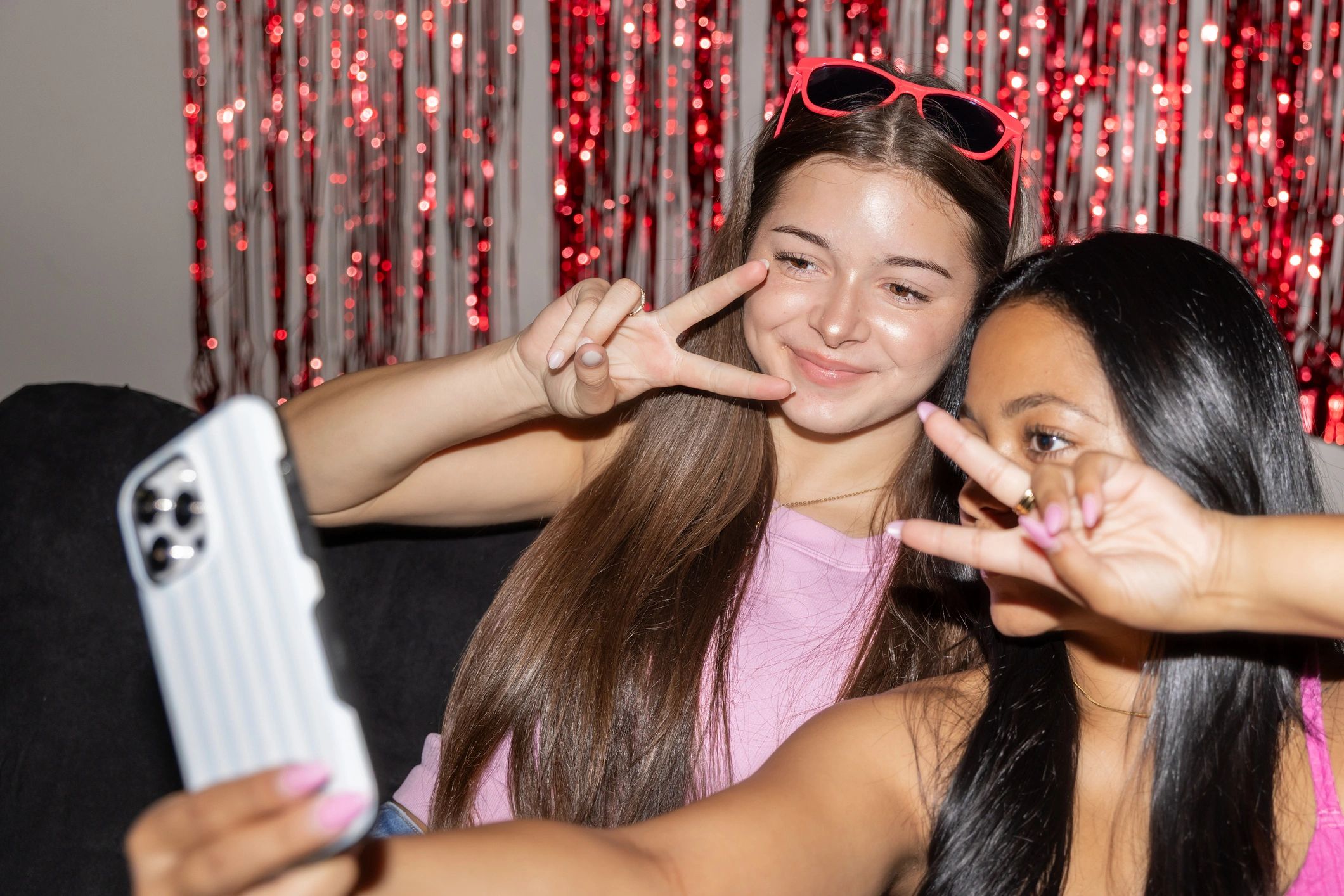 Friends smiling and taking selfies at a party